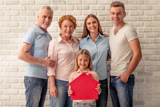 Haus-Familie-Wohnen-Serie-12-4 Glückliche Familie steht vor einer Wand und freut sicht.